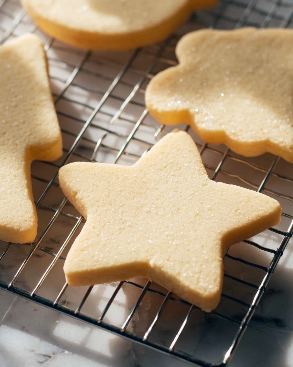 The image shows several thick, light beige sugar cookies cooling on a metal wire rack. The cookies have smooth, slightly grainy textures and are shaped into Christmas shapes, including a star and part of a bell visible on the sides. The wire rack sits on a white marbled surface with soft light casting gentle shadows from the cookies and rack wires. The cookies' edges are clean and slightly rounded, showing a soft baked finish without any decoration. Photo taken with an iphone --ar 4:5 --v 7