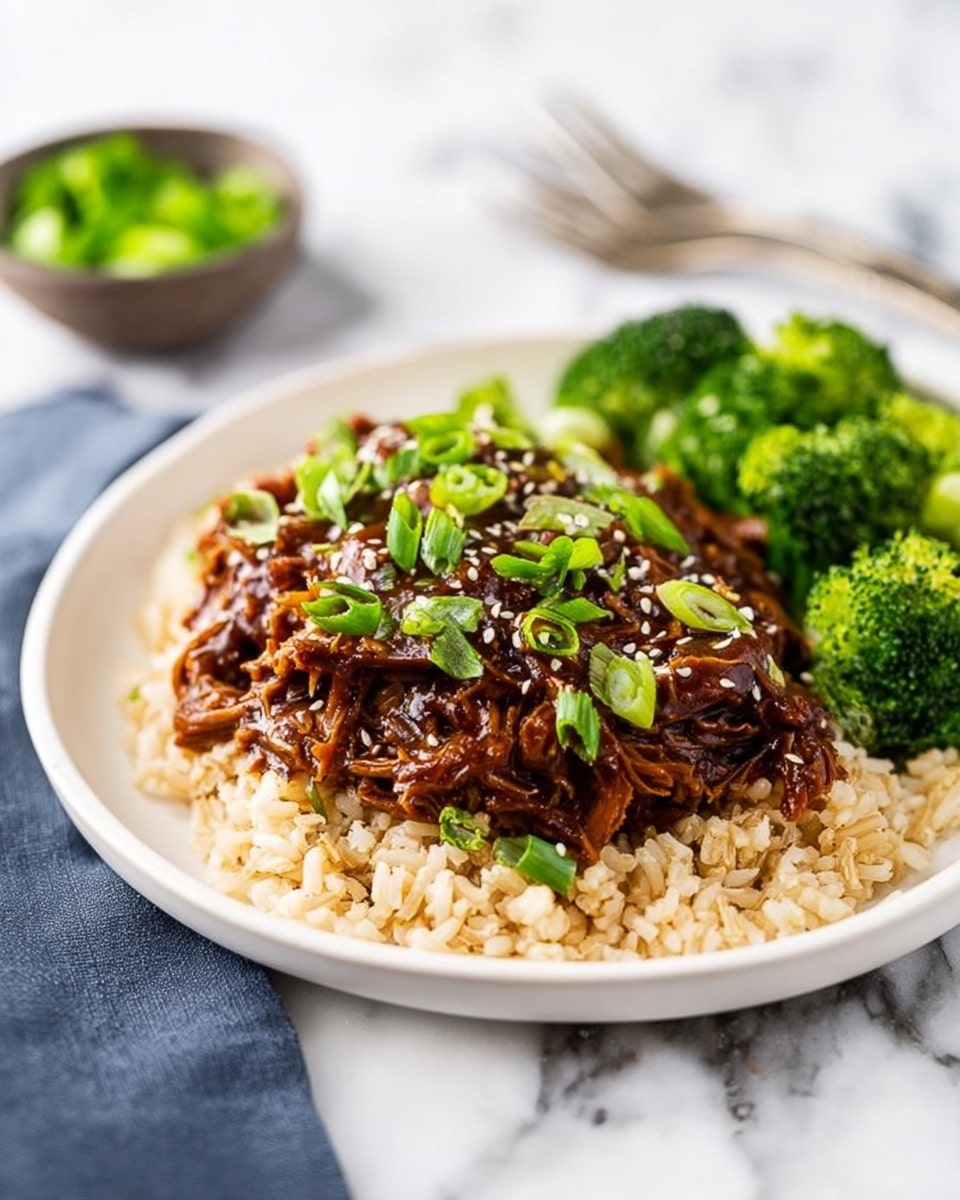 A white plate holds a layered dish with a base of light brown rice spread evenly across the bottom. On top of the rice, there is a thick layer of dark brown shredded meat covered in a glossy sauce, garnished with bright green sliced scallions and sprinkled with small white sesame seeds. To the side of the meat and rice, there is a portion of vibrant green broccoli florets that look steamed and tender. The plate rests on a white marbled surface with a blurred background where a small bowl with green garnish and a fork are faintly visible. Photo taken with an iphone --ar 4:5 --v 7