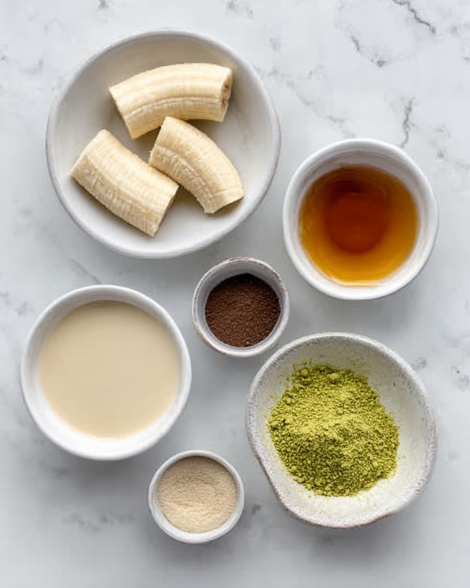 The image shows five white bowls arranged on a white marbled surface. One bowl contains three pieces of peeled banana, showing a pale yellow color and soft texture. Another bowl is filled with a smooth light beige liquid that looks creamy. A small bowl holds a dark brown powder with a fine texture. There is also a bowl with a thick golden-brown syrup. Finally, a bowl contains bright green powder with a fine, sifted texture. Photo taken with an iphone --ar 4:5 --v 7