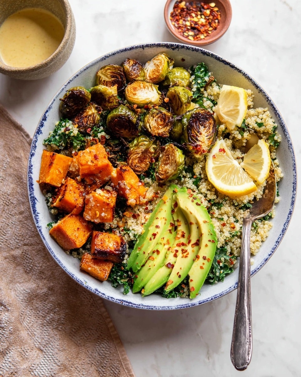 The dish is a bowl with four main layers. The bottom layer is a bed of fluffy, light-colored quinoa mixed with small green kale leaves. On top of the quinoa, there are crispy roasted Brussels sprouts, golden brown on the edges, placed on one side. Next to them are bright orange roasted cubes of sweet potato, seasoned with spices. Two slices of creamy avocado with a light green color and smooth texture are placed on opposite sides of the bowl, lightly sprinkled with red pepper flakes. Two lemon wedges rest on the side, and a silver spoon is inside the bowl. The bowl is white with a blue edge, set on a white marbled surface with a spoon and a small dish of red pepper flakes nearby. Photo taken with an iphone --ar 4:5 --v 7
