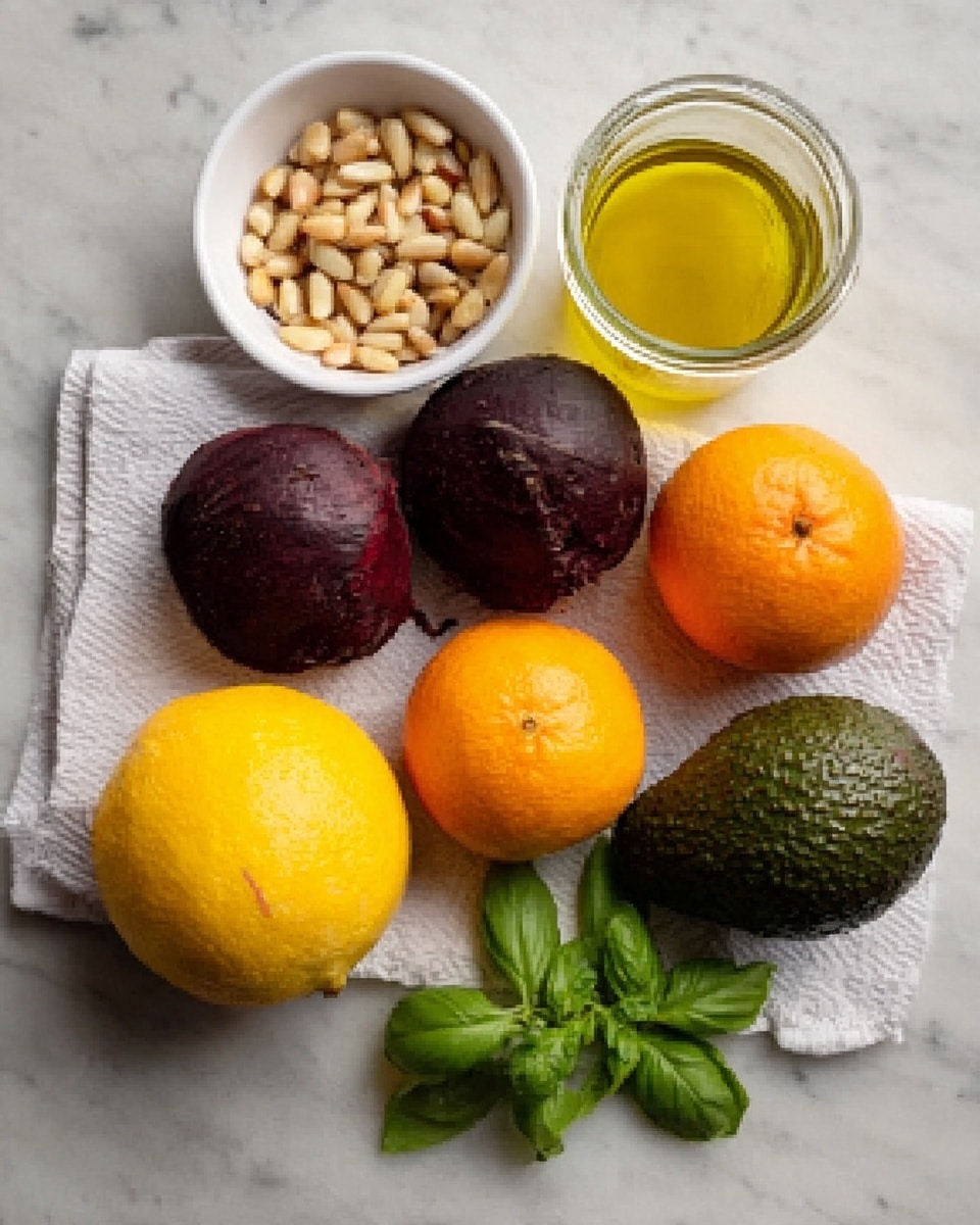 The image shows a white marble surface with several ingredients arranged neatly. There is a small white bowl filled with pine nuts on the upper left, two dark brown beets placed on a white cloth below it, and a whole dark green avocado positioned to the right of the beets. Two small oranges and one larger yellow grapefruit are clustered together in the center-right area. A glass jar filled with yellow oil is on the far right. A small sprig of fresh green basil leaves is placed next to the white bowl of pine nuts. Photo taken with an iphone --ar 4:5 --v 7