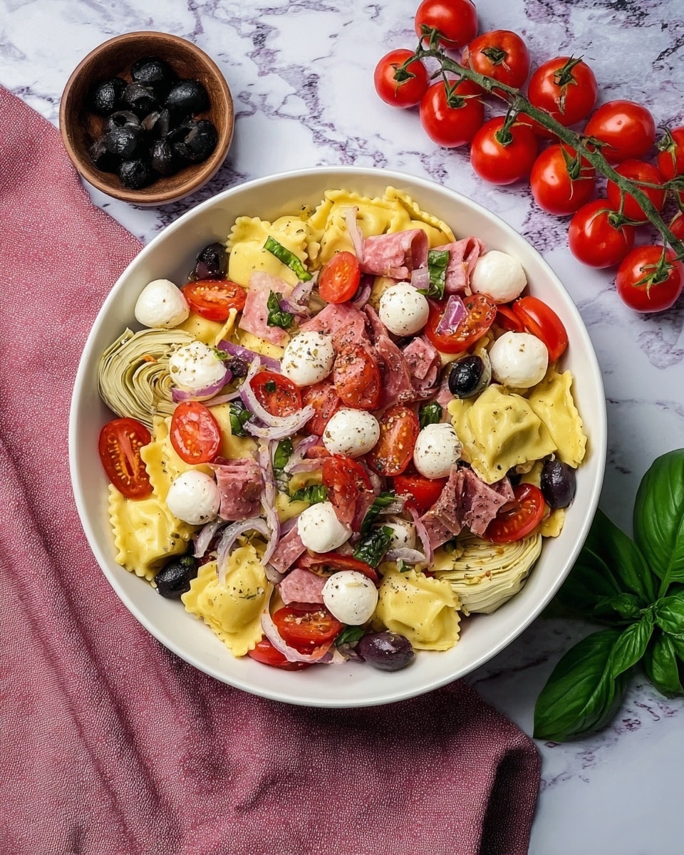 A white round bowl filled with a colorful ravioli pasta salad. The bottom layer is yellow ravioli with a smooth texture and ruffled edges, topped with small white mozzarella balls scattered around. On top of the ravioli, there are bright red cherry tomato halves and whole cherry tomatoes, mixed with dark black olives and thin slices of pink salami. Pieces of light green artichoke and chopped red onion add more color and texture. Small green basil leaves are sprinkled on top, with bits of red bell pepper adding extra brightness. The bowl is placed on a white marbled surface with a pink cloth next to it, a small brown bowl of black olives above it, and a cluster of whole red cherry tomatoes on the vine at the top right. Photo taken with an iphone --ar 4:5 --v 7