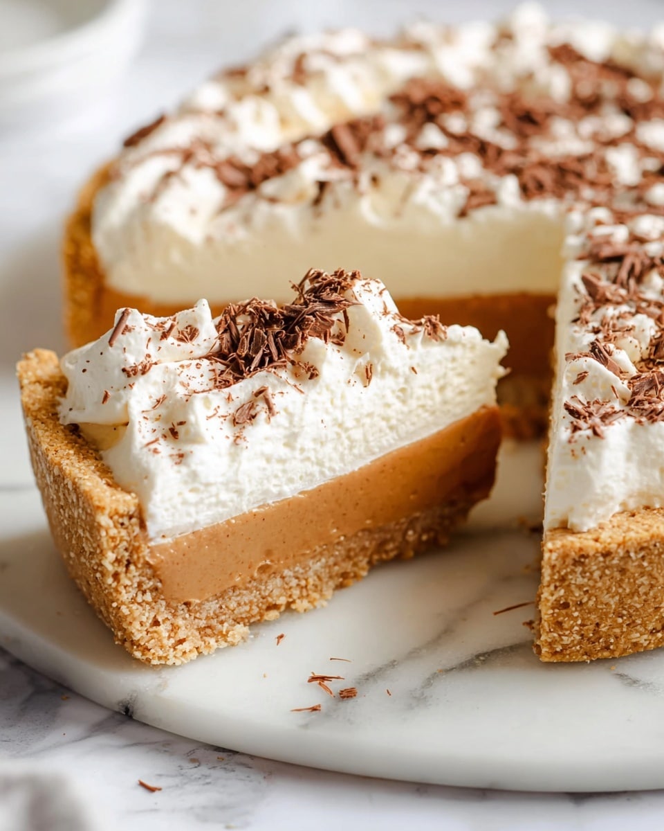 The image shows a slice of pie on a white marbled surface with three distinct layers: a thick, crumbly light brown crust at the bottom, a smooth caramel-colored filling in the middle, and a tall, fluffy white whipped cream topping on top. The whipped cream is sprinkled with fine dark brown chocolate shavings, adding texture and color contrast. The pie slice is next to the rest of the pie, which reveals similar layers and textures. Photo taken with an iphone --ar 4:5 --v 7